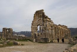 Image du Maroc Professionnelle de  Les touristes se rassemblent autour des arches de la basilique, le principal bâtiment administratif de Volubilis.
Le site de Volubilis est l'un des sites les mieux préservés au Maroc et le plus visité. La cité romaine se situe à proximité de Moulay Idriss Zerhoun à une trentaine de km au nord-ouest de Meknès, photo prise le jeudi 8 Mars 2012. Volubilis ville antique berbère Walili (Lauriers rose) qui date du 3e siècle avant J.-C. capitale du royaume de Maurétanie fondé comme seconde capital sous le règne de Juba II. (Photo / Abdeljalil Bounhar)
 